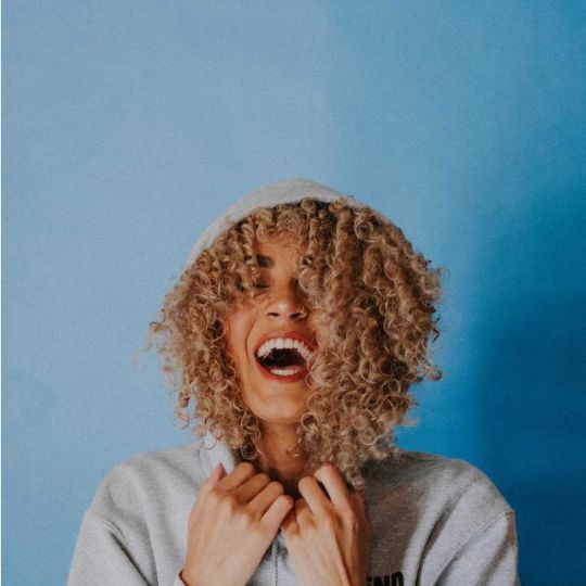 Female with very curly hair laughing
