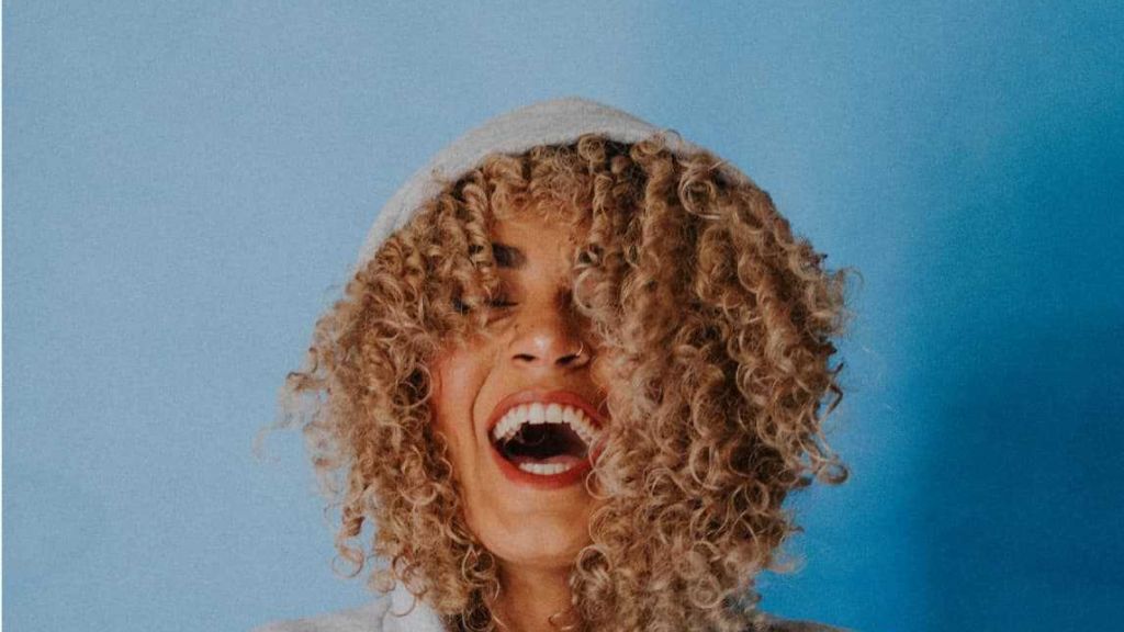 Female with very curly hair laughing