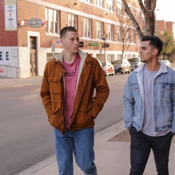 Two male students walking along a path and talking