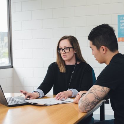Advocacy staff member sitting at table with student looking at the laptop screen