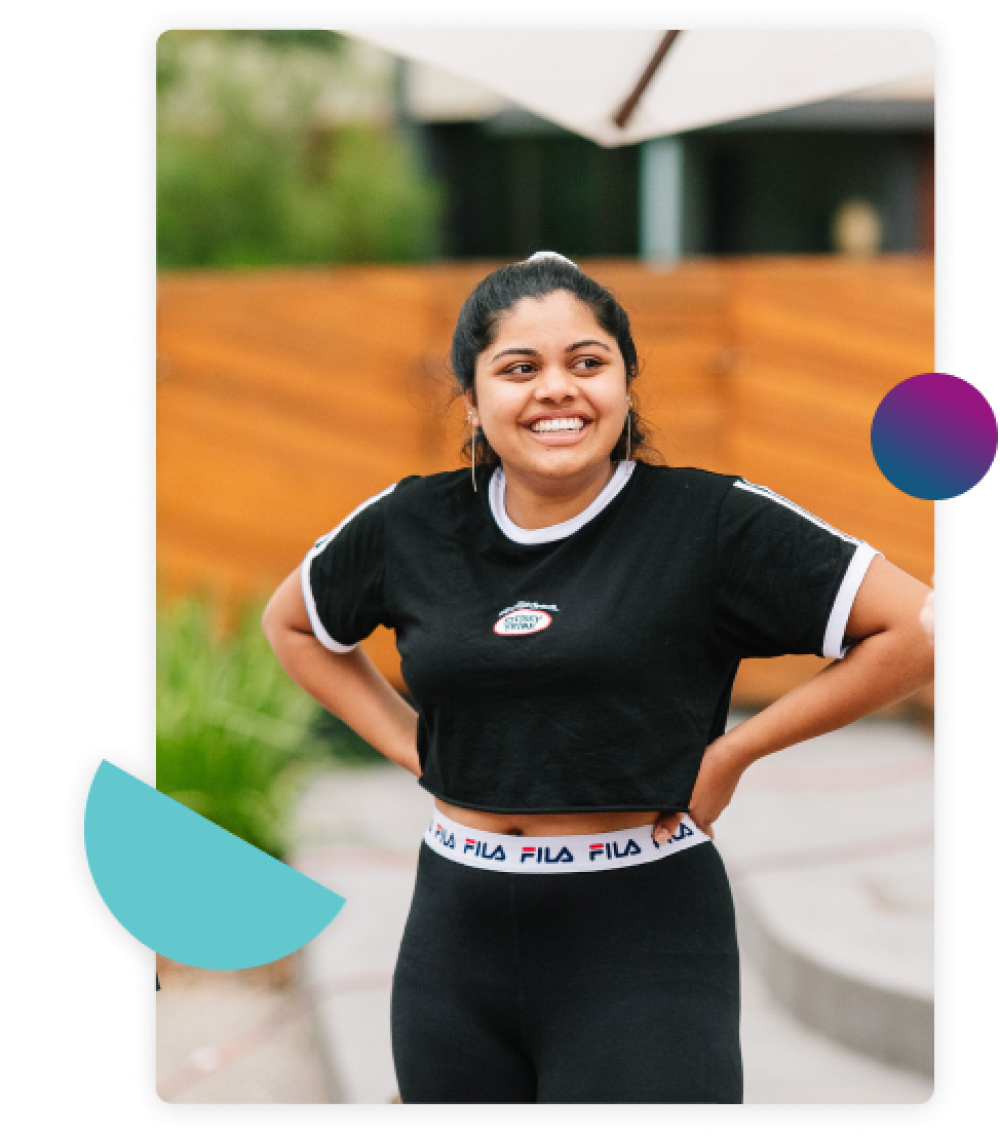 Female student smiling and standing with her hands on her hips