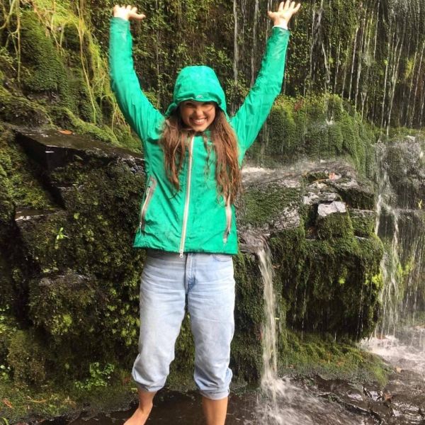 Female student with her arms in the air while laughing