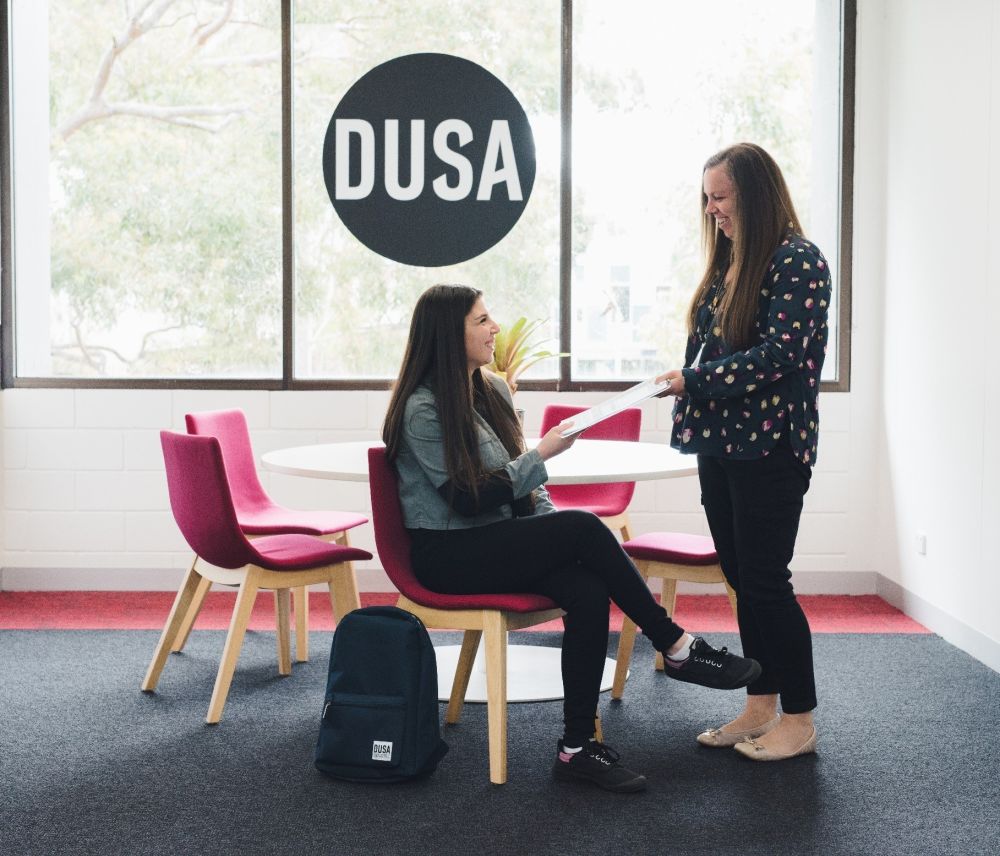 Advocacy team member smiling and talking with student while handing her some information