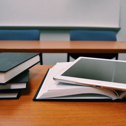 Textbooks and a ipad sitting on top of a table
