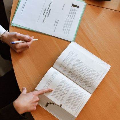 A textbook, papers and a calculator sitting on a table
