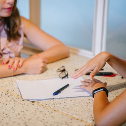 Two females sitting at a table talking