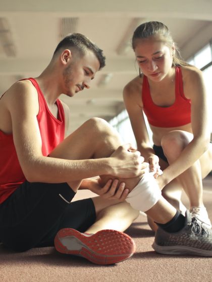Female student applying a bandage to a male student during a First Aid class
