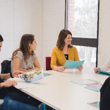 Group of students and Advocacy staff sitting around a table talking