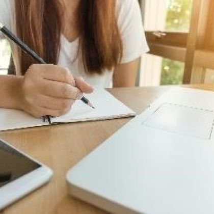 Female sitting at a desk in front of a laptop filling out a form