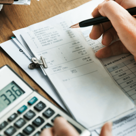 A calculator with receipts and bills placed on a table