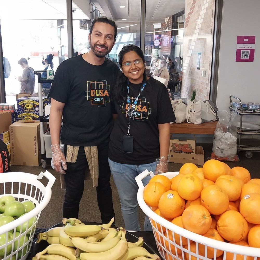 Food pantry image - two DUSA crew volunteers smiling into the camera