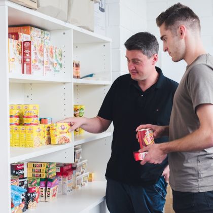 Advocacy staff member offering student food staples at the DUSA Survival centre