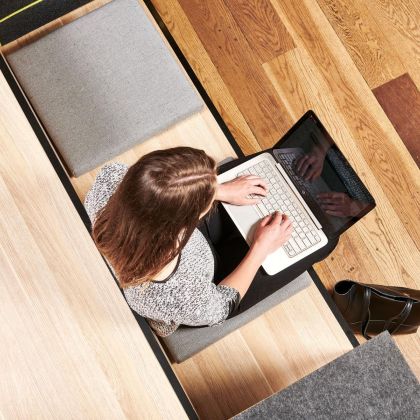 student sitting on bench seat using her laptop